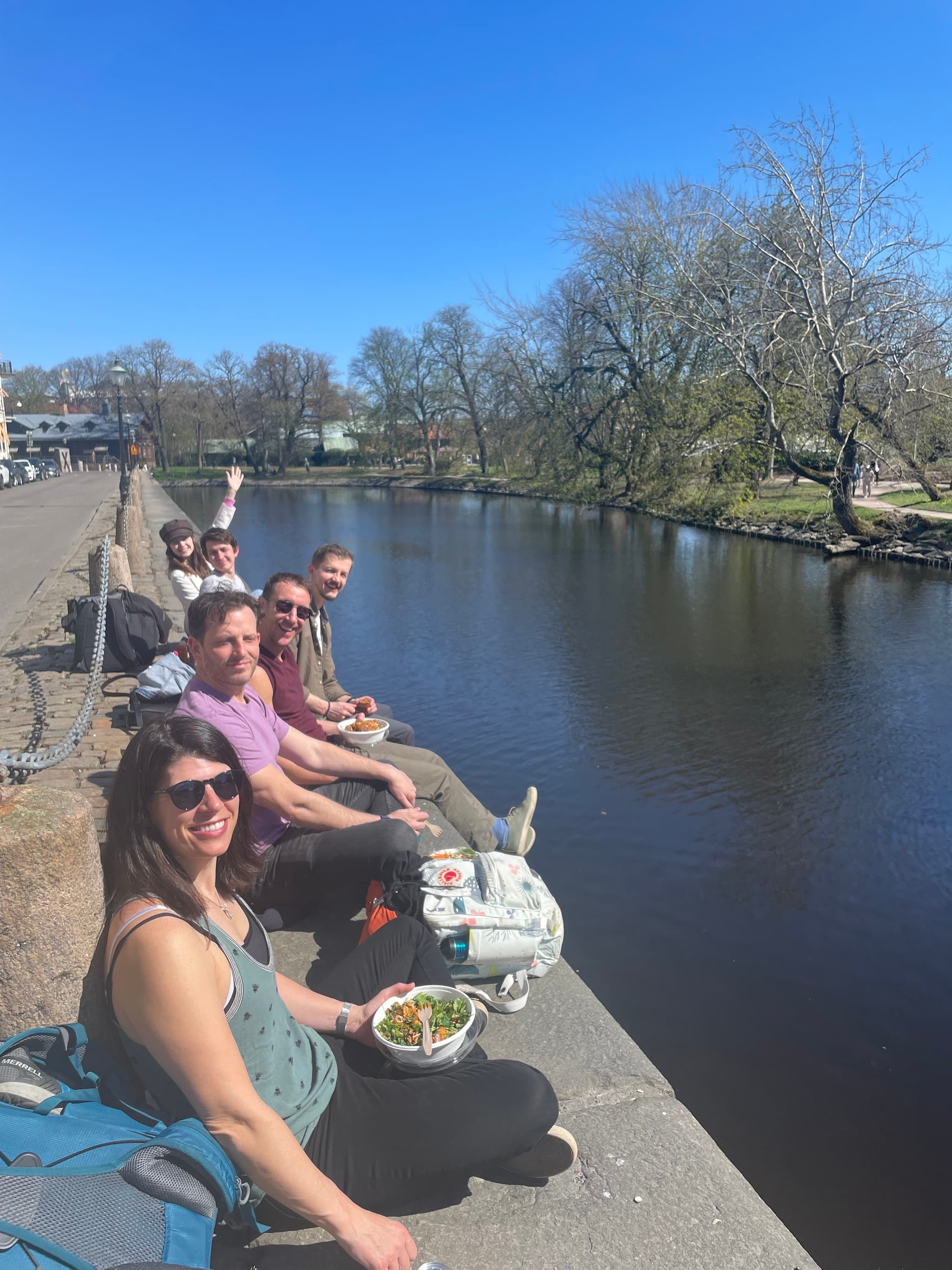 Team sitting along a canal wall