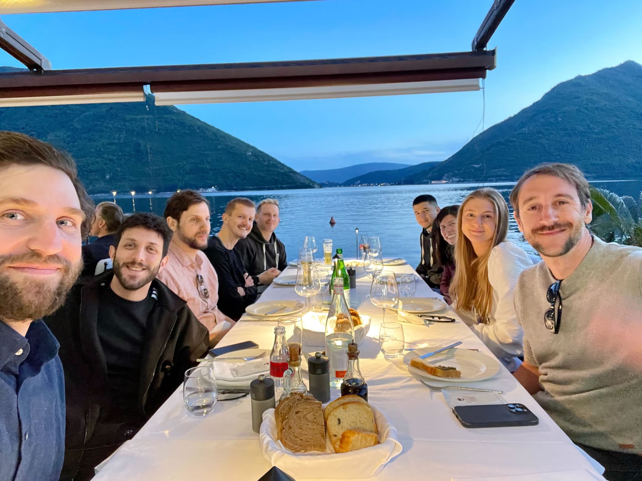 Team dinner by the water at dusk