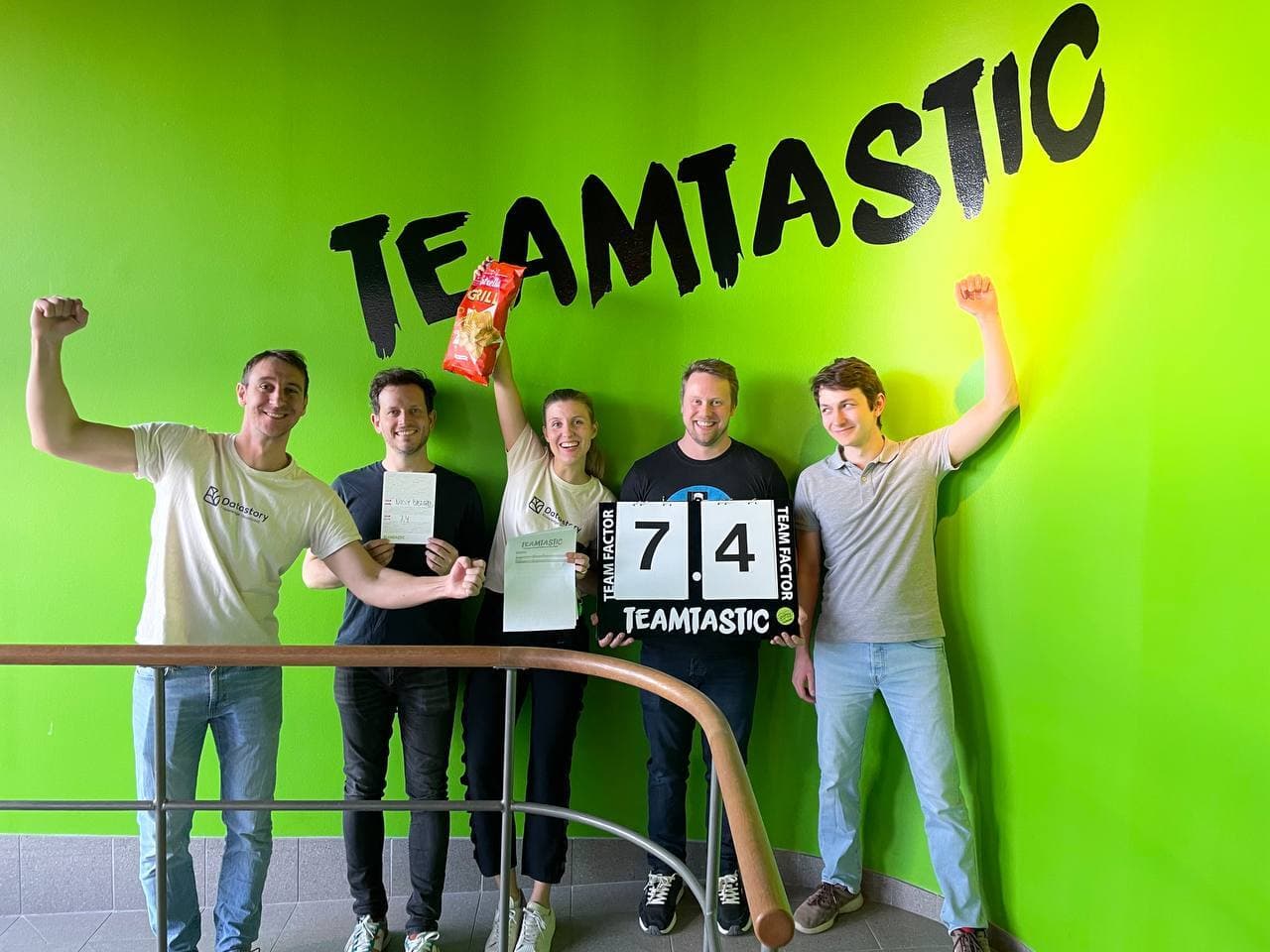 Team celebrating in front of a TEAMTASTIC wall